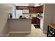 Open-concept kitchen with dark wood cabinets, modern appliances, and breakfast bar at 4965 Indian River Dr # 101, Las Vegas, NV 89103