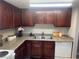Kitchen featuring dark wood cabinets, speckled granite countertops and a white dishwasher at 4965 Indian River Dr # 101, Las Vegas, NV 89103