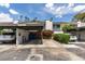 Well-maintained townhome with carport and landscaped front yard featuring mature trees and colorful flowers at 516 Delfern Ln, Las Vegas, NV 89169