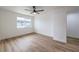 Bright bedroom featuring wood floors, a ceiling fan, and a large window with a view at 5335 Rod Ct # 103, Las Vegas, NV 89122
