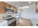 Modern kitchen featuring stainless steel appliances, light wood cabinets, and a dining space at 5335 Rod Ct # 103, Las Vegas, NV 89122