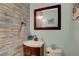 Quaint powder room with rustic-style wall covering, decorative mirror, and modern faucet at 5642 Breckenridge St, North Las Vegas, NV 89081