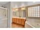 Bright bathroom featuring double sinks, a glass shower and a tub at 5642 Breckenridge St, North Las Vegas, NV 89081
