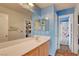 Bright bathroom featuring a single sink vanity, large mirror, and a separate shower and toilet area at 5642 Breckenridge St, North Las Vegas, NV 89081