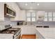 Charming kitchen features white cabinets, stainless steel appliances, and stylish tile backsplash at 5642 Breckenridge St, North Las Vegas, NV 89081