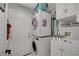 Bright laundry room with stacked washer/dryer, utility sink, and cabinet storage at 5642 Breckenridge St, North Las Vegas, NV 89081