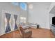 Bright living room with high ceilings, wood floors, comfortable seating, and large windows for natural light at 5642 Breckenridge St, North Las Vegas, NV 89081