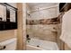 Tiled bathroom featuring a shower-tub with glass doors and modern fixtures at 6117 Foxcroft Ave, Las Vegas, NV 89108