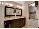 Bathroom with a double sink vanity, large framed mirror, and a tiled shower and tub combo at 6117 Foxcroft Ave, Las Vegas, NV 89108