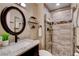 Bathroom showcasing a modern vanity, round mirror, and frameless glass shower at 6117 Foxcroft Ave, Las Vegas, NV 89108