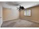Large bedroom with plush carpet, ceiling fan, and shuttered window at 6117 Foxcroft Ave, Las Vegas, NV 89108