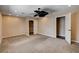 Large carpeted bedroom featuring a ceiling fan, closet, and access to the hallway at 6117 Foxcroft Ave, Las Vegas, NV 89108