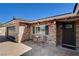 Charming brick home featuring a cozy front porch, black iron door, and updated exterior fixtures at 6117 Foxcroft Ave, Las Vegas, NV 89108