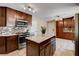 Renovated kitchen features granite countertops, stainless steel appliances, stylish backsplash, and a functional kitchen island at 6117 Foxcroft Ave, Las Vegas, NV 89108