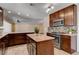 Modern kitchen featuring an island, granite countertops, stainless steel appliances, and tile flooring at 6117 Foxcroft Ave, Las Vegas, NV 89108