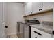 Well-organized laundry room featuring modern washer and dryer units, granite countertops, and plenty of cabinet space at 6117 Foxcroft Ave, Las Vegas, NV 89108