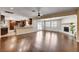 Open-concept living space with hardwood floors, a fireplace, and a kitchen view at 6117 Foxcroft Ave, Las Vegas, NV 89108