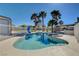 Backyard oasis featuring a sparkling pool, lush palm trees, and privacy fencing at 6117 Foxcroft Ave, Las Vegas, NV 89108