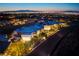 Striking aerial view of a modern home featuring an attached garage, complemented by breathtaking city views at dusk at 621 Majestic Rim Dr, Henderson, NV 89012