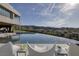 Backyard featuring a large infinity pool, patio seating, and a golf course view with mountain backdrop at 621 Majestic Rim Dr, Henderson, NV 89012