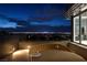 Balcony featuring a round wicker lounge with cocktails and city views at night at 621 Majestic Rim Dr, Henderson, NV 89012