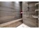 Sleek bathroom shower featuring wood-look tile and a built-in bench for a spa-like experience at 621 Majestic Rim Dr, Henderson, NV 89012