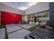 Stylish courtyard featuring modern furniture, a rock fire pit, and a vibrant red accent wall at 621 Majestic Rim Dr, Henderson, NV 89012