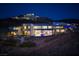 Expansive modern home on a hillside showcasing a luxurious pool and stunning city views at night at 621 Majestic Rim Dr, Henderson, NV 89012