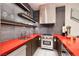 Stylish kitchen featuring stainless steel appliances, modern cabinets, and a spacious red countertop at 621 Majestic Rim Dr, Henderson, NV 89012