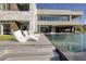 Luxury home featuring an infinity pool, modern architecture, and stylish lounge chairs for outdoor relaxation at 621 Majestic Rim Dr, Henderson, NV 89012