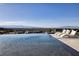 Picturesque infinity pool overlooking the city skyline, complete with lounge seating and lush landscaping at 621 Majestic Rim Dr, Henderson, NV 89012