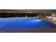 Elegant infinity pool with underwater lighting, offering stunning views of the city skyline at night at 621 Majestic Rim Dr, Henderson, NV 89012