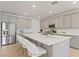 Modern kitchen featuring a large center island with bar stool seating, stainless steel appliances, and stylish gray cabinetry at 6270 Lamont Hills Ave, Las Vegas, NV 89139