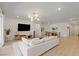 Open living area with white sofa, tv, and wood floors creates a spacious and modern living space at 6270 Lamont Hills Ave, Las Vegas, NV 89139