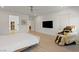 Light-filled main bedroom boasts wood floors, ceiling fan, wall-mounted TV, and a comfortable massage chair at 6270 Lamont Hills Ave, Las Vegas, NV 89139
