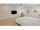 Airy bedroom with wood floors, a ceiling fan, a wall-mounted TV, and serene natural light from two windows at 6270 Lamont Hills Ave, Las Vegas, NV 89139