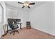 Carpeted bedroom with a ceiling fan, window, and a desk with a computer setup at 6379 Dundock Ave, Las Vegas, NV 89122