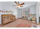 Bedroom with floral wall decor, crib, window with curtains, and carpet flooring at 6379 Dundock Ave, Las Vegas, NV 89122