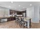 Modern kitchen with bar seating, granite countertops, and dark cabinets, offering ample space for cooking at 6379 Dundock Ave, Las Vegas, NV 89122