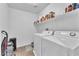 Efficient laundry area with washer, dryer, and overhead shelving for organized storage at 6379 Dundock Ave, Las Vegas, NV 89122