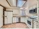 Functional kitchen featuring white cabinetry, tile flooring, stainless steel appliances, and ample counter space at 6417 Plumcrest Rd, Las Vegas, NV 89108