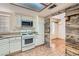 Functional kitchen featuring white cabinetry, tile flooring, stainless steel appliances, and adjacent dining area at 6417 Plumcrest Rd, Las Vegas, NV 89108