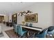 Dining room features a black table, comfortable blue chairs, modern light fixture, and colorful rug at 668 Falcon Summit Ct, Henderson, NV 89012