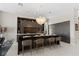Spacious kitchen with a black countertop island and seating, showcasing modern appliances and stylish pendant lighting at 668 Falcon Summit Ct, Henderson, NV 89012