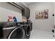 Well-lit laundry room with front-loading machines and cabinet storage at 668 Falcon Summit Ct, Henderson, NV 89012