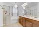 Bright bathroom featuring dual vanity sinks, large mirror, and shower with glass door at 6814 Willowcroft St, Las Vegas, NV 89149