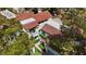 Aerial view of a residential neighborhood showcasing townhomes with red tile roofs surrounded by lush greenery at 6925 Emerald Springs Ln, Las Vegas, NV 89113