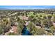 Elevated aerial view showcases community near golf course with lush mature trees and tile roofs at 6925 Emerald Springs Ln, Las Vegas, NV 89113