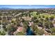 Expansive aerial view of community with lush greenery, a golf course, and the mountain range on the horizon at 6925 Emerald Springs Ln, Las Vegas, NV 89113