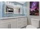 Stylish bathroom with blue tile accents, white vanity, and illuminated mirror at 6925 Emerald Springs Ln, Las Vegas, NV 89113